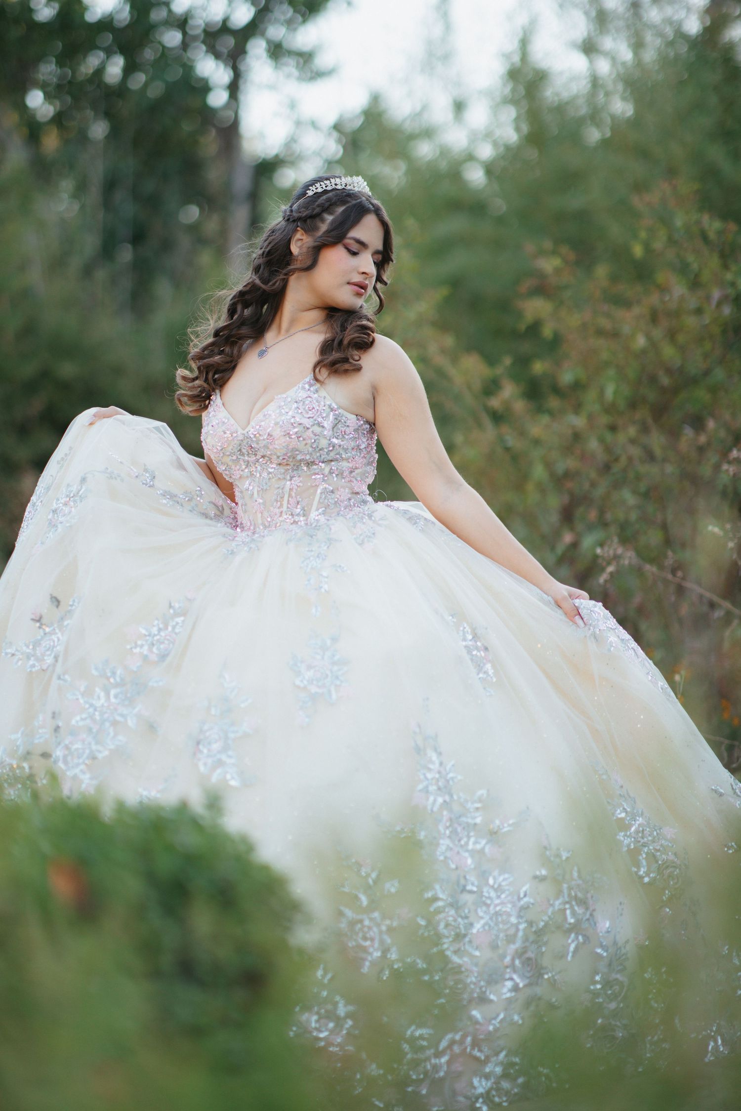 Romantic bridal photo featuring intricate lace details on a white ballgown in a garden setting.