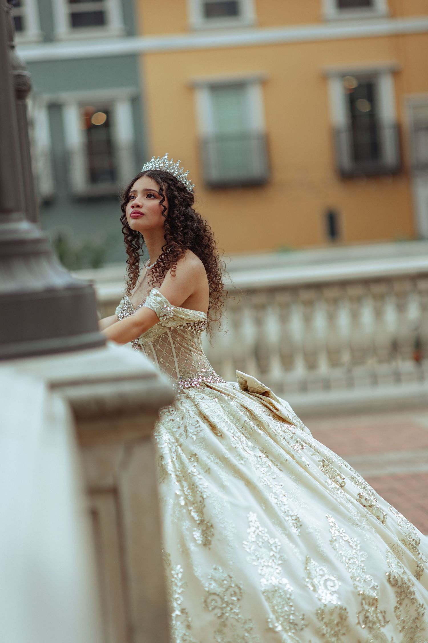 A flowing white ball gown with crystal details twirls against an urban backdrop.
