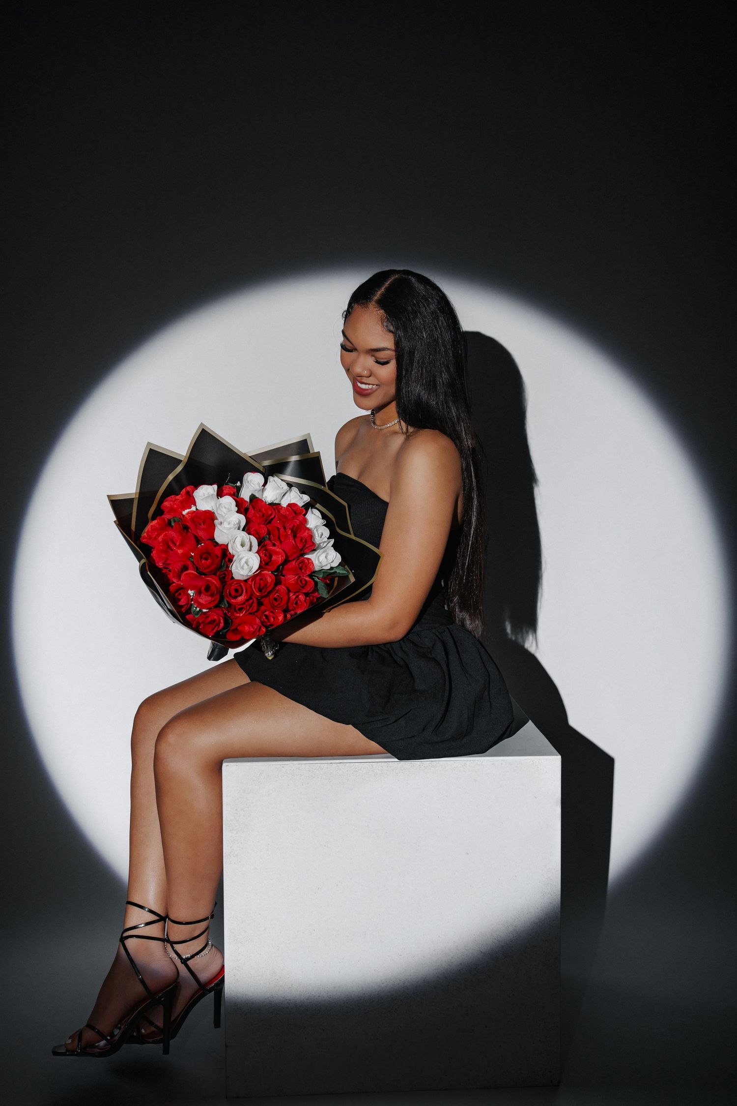 Artistic photo series showing red and white roses against dramatic spotlight on dark background.