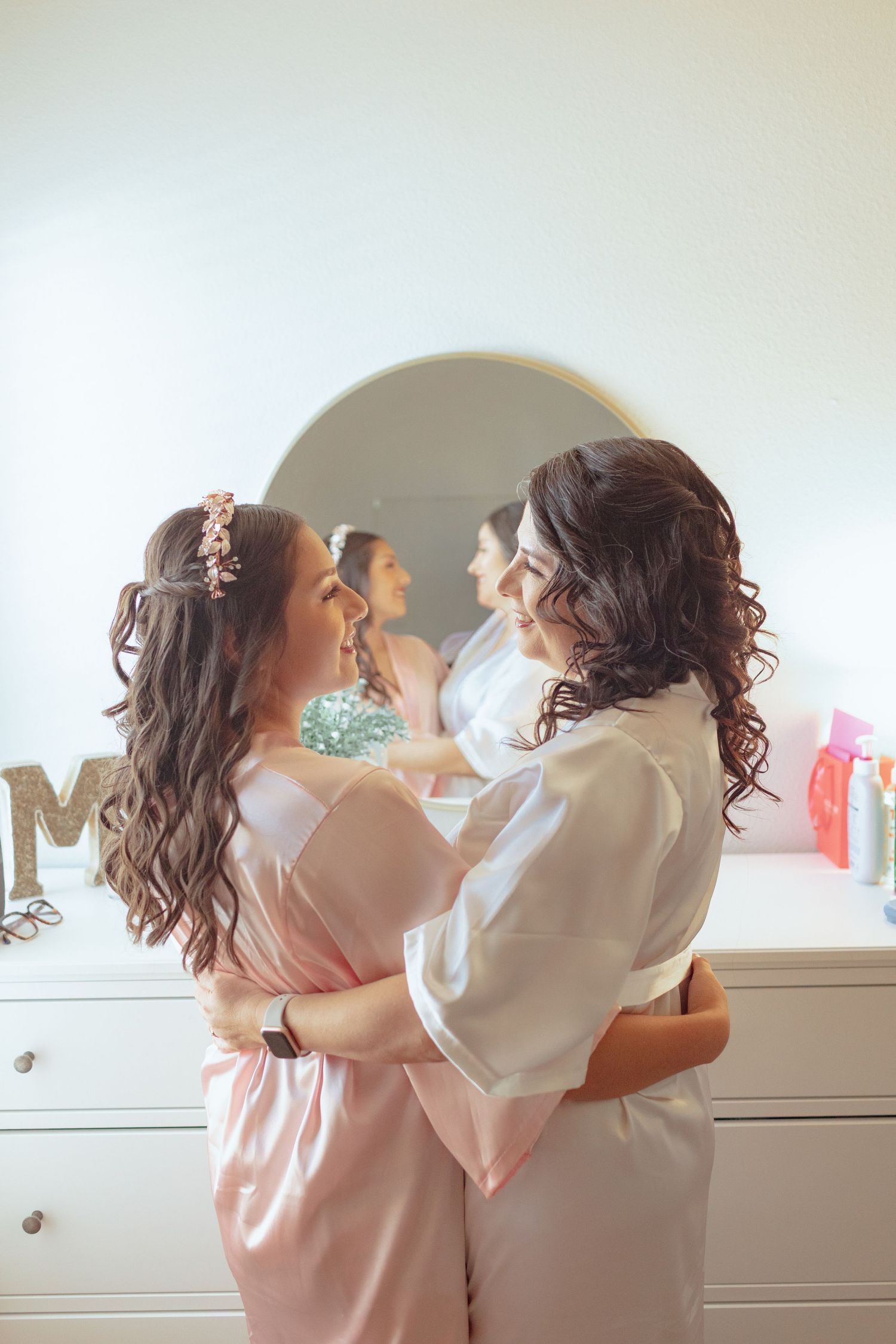 Wedding party in matching pink robes sharing a joyful moment together.