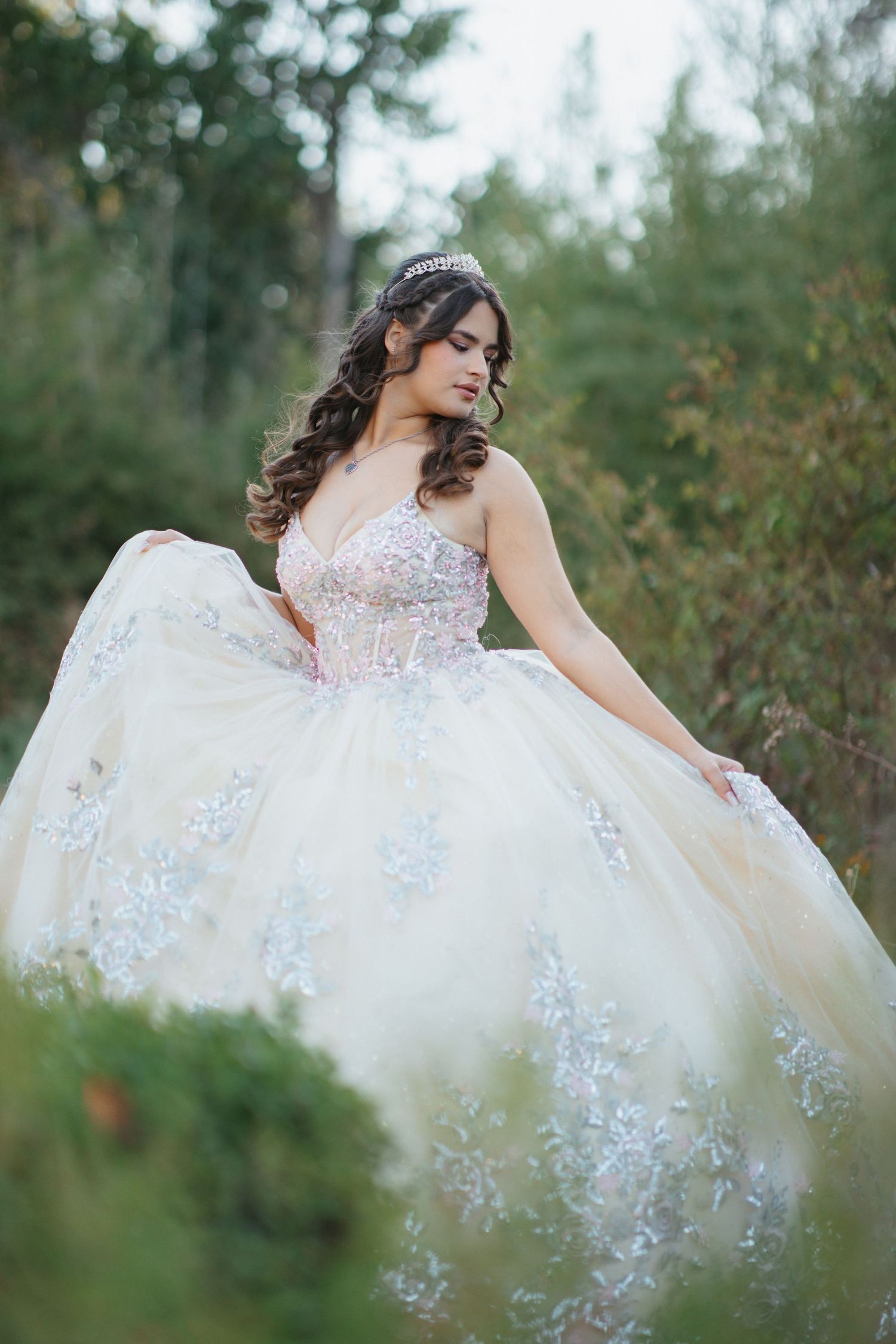 Ethereal bridal portrait featuring princess ball gown with delicate lace details in forest setting.