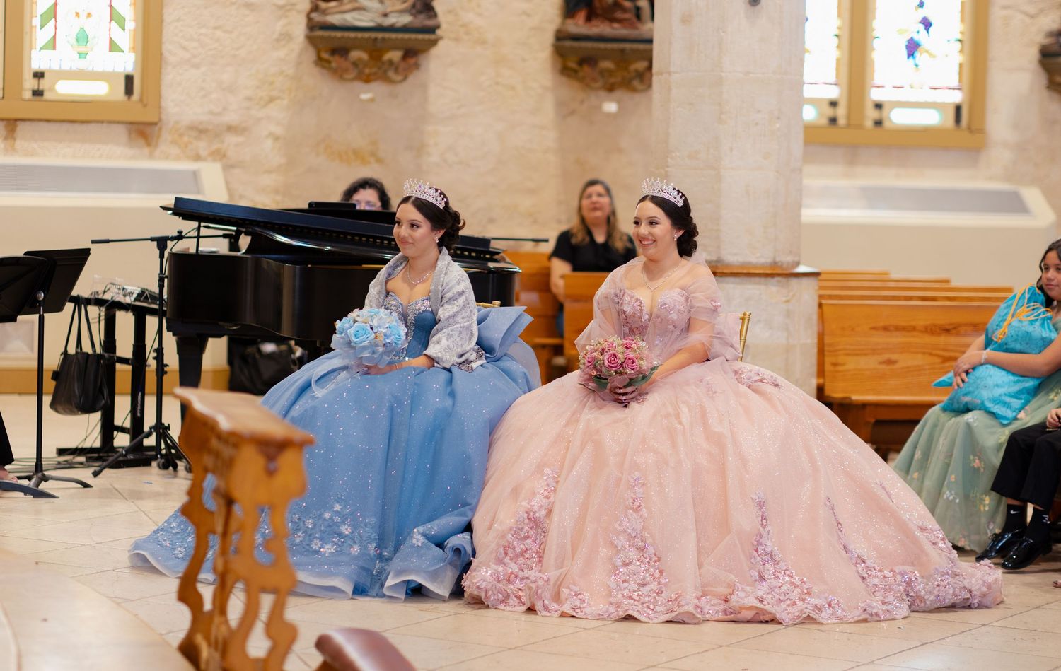 Elegant ball gowns in pink and blue during formal church celebration.