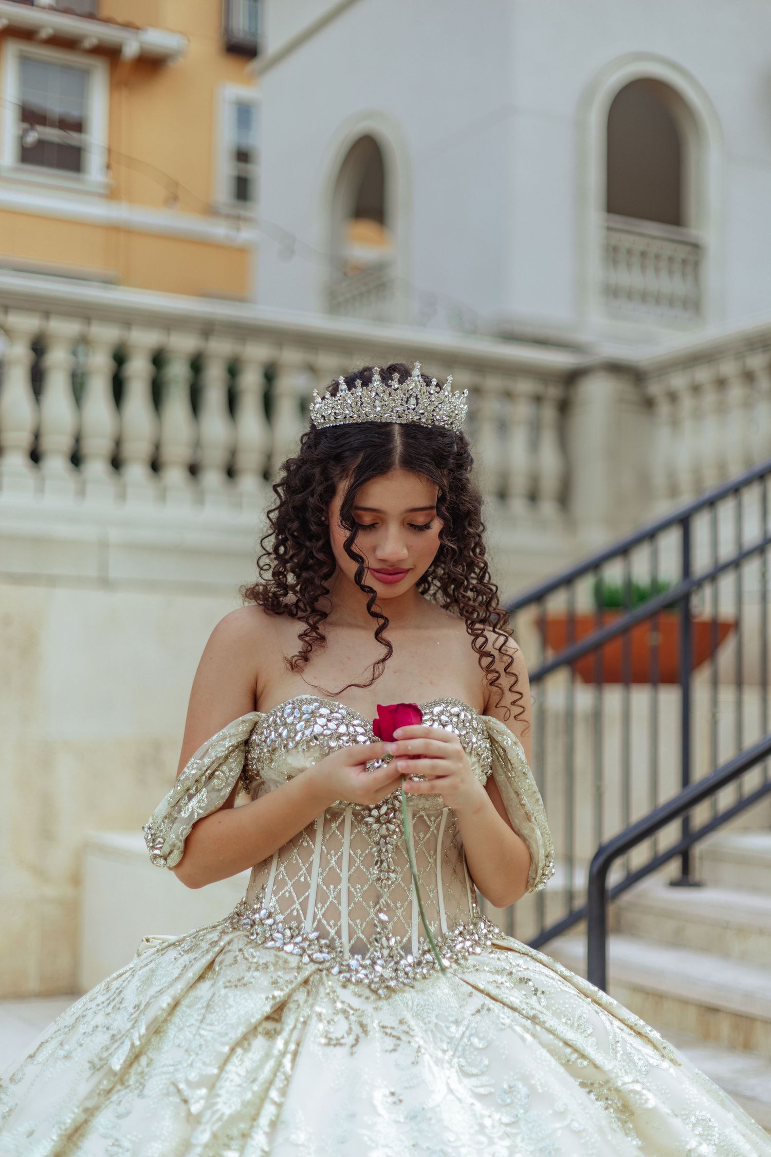 A princess-style wedding dress sparkles in natural light against Mediterranean architecture.