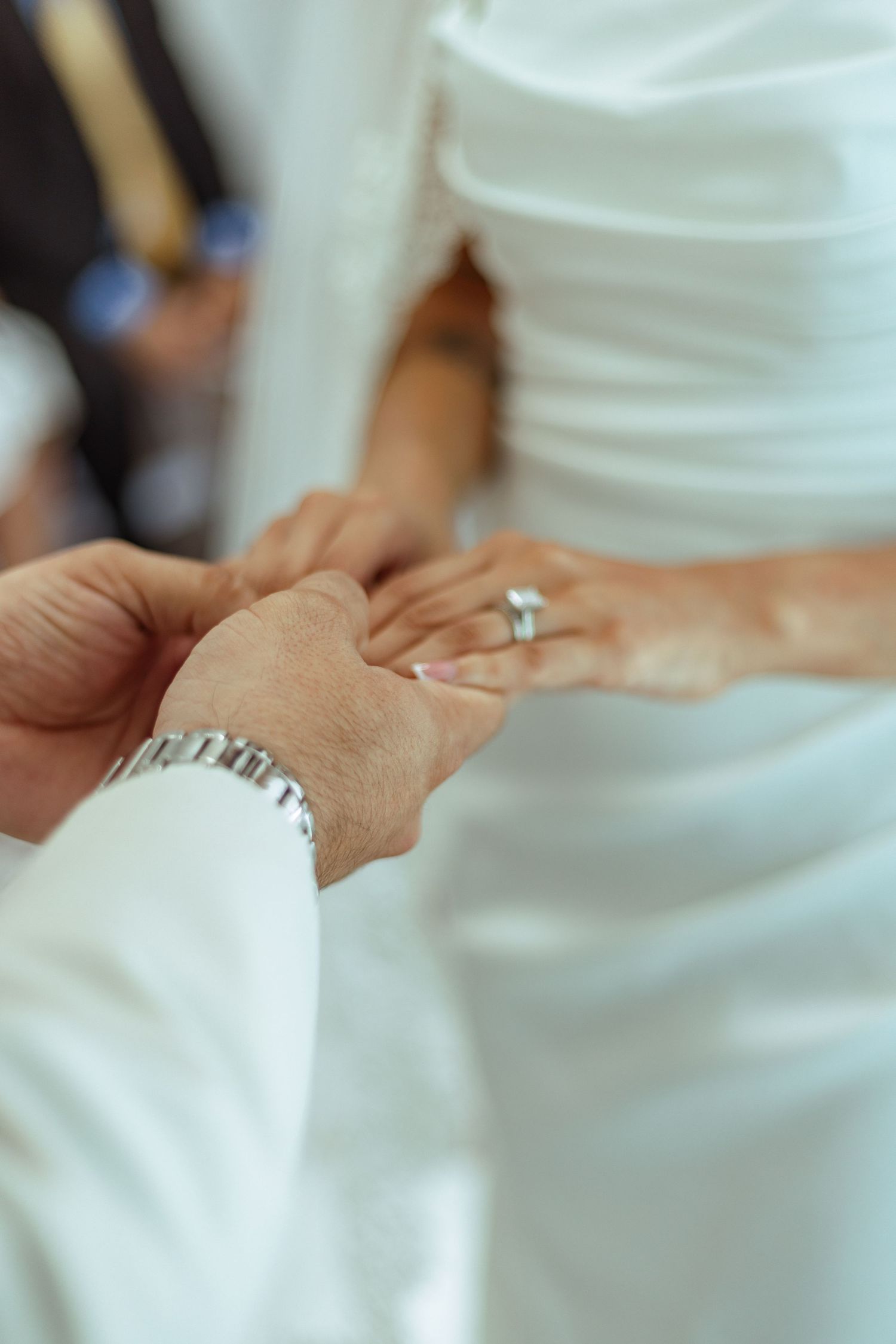 Close-up of hands exchanging rings during a wedding ceremony.