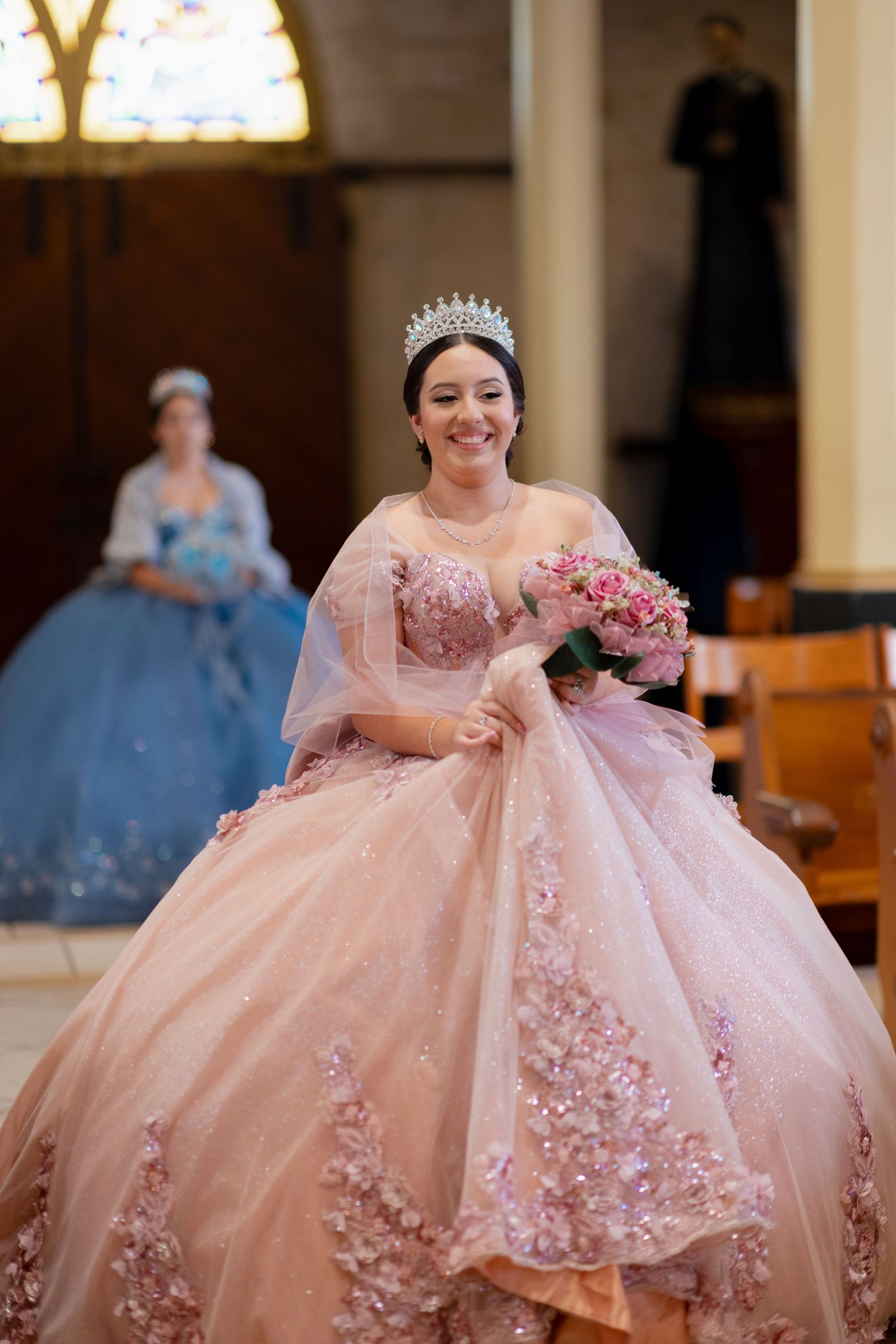 A pink ballgown with floral appliques sparkles in a church setting.