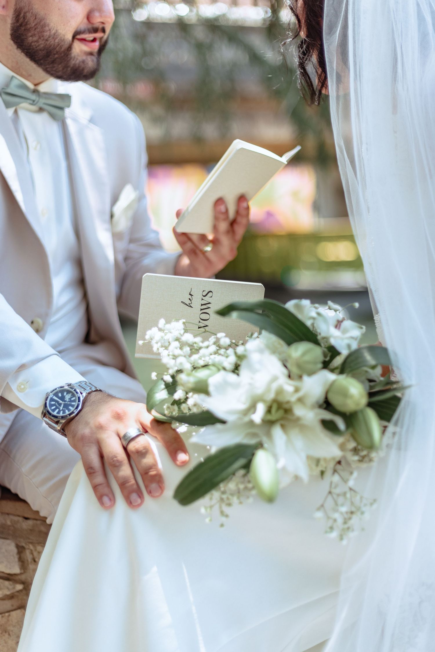 Close-up details of wedding ceremony with white floral arrangements and veil.