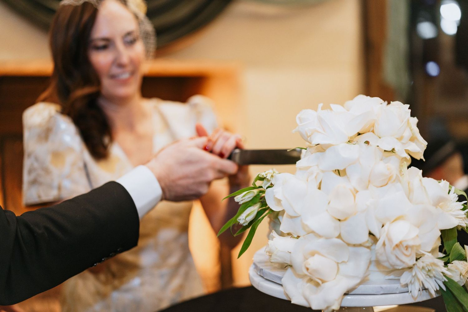 White floral centerpieces and table settings at elegant wedding reception.