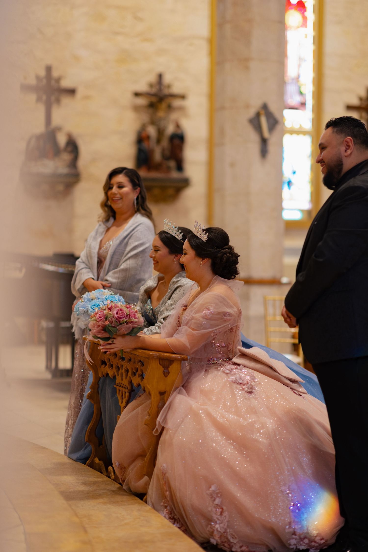 Elegant ball gowns and formal attire during a traditional church ceremony with stained glass windows.