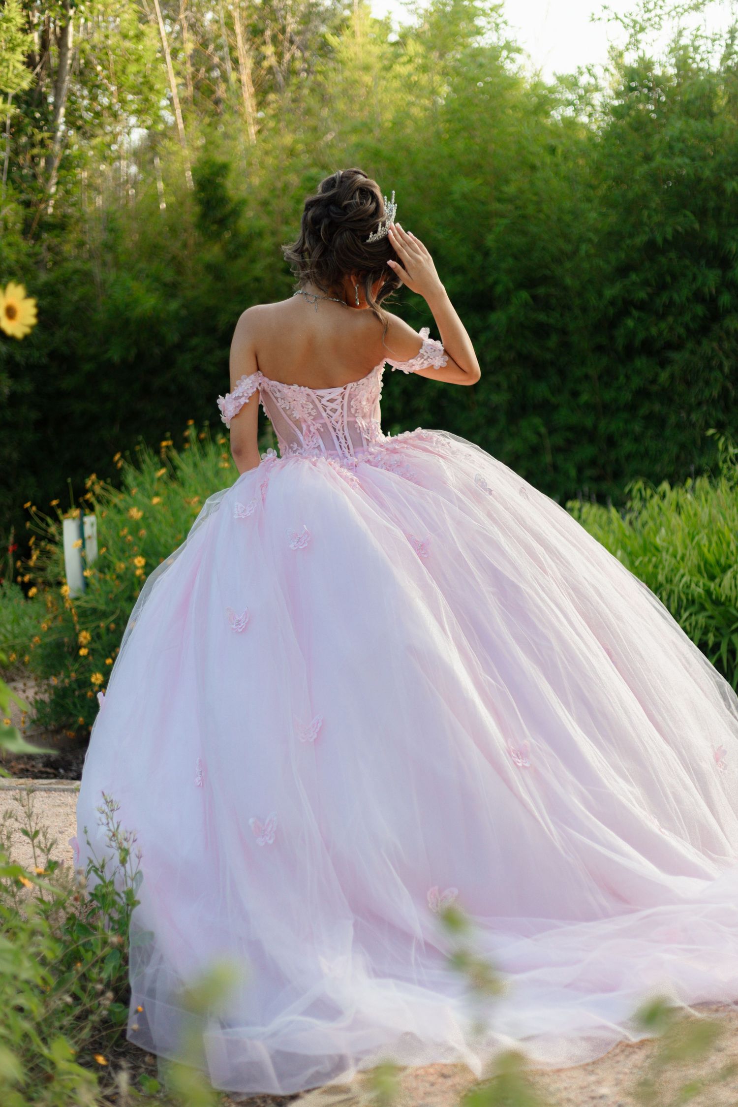 Side view of an elegant ballgown dress flowing in an outdoor garden setting.