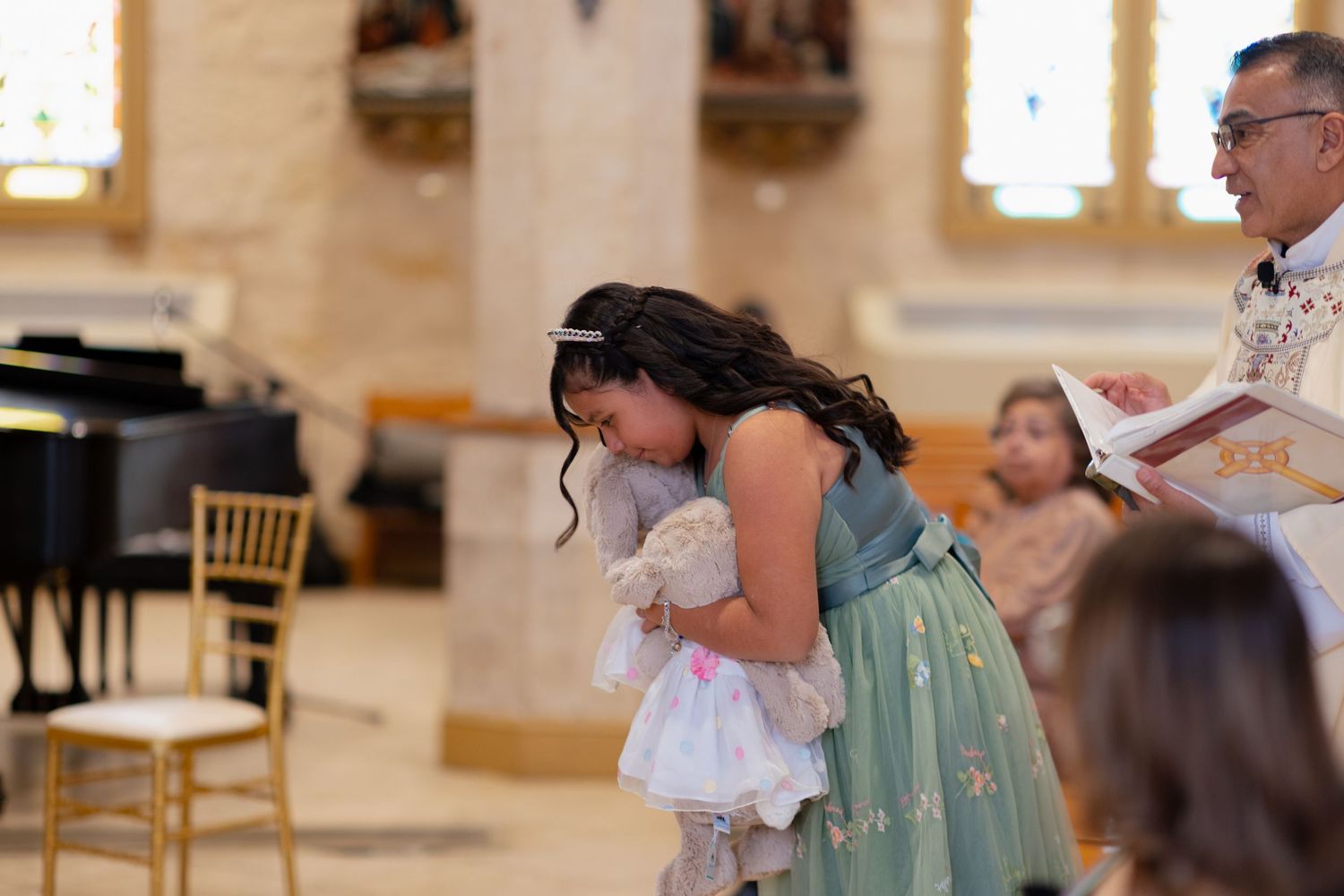 Traditional religious ceremony with attendees in formal attire inside decorated church.
