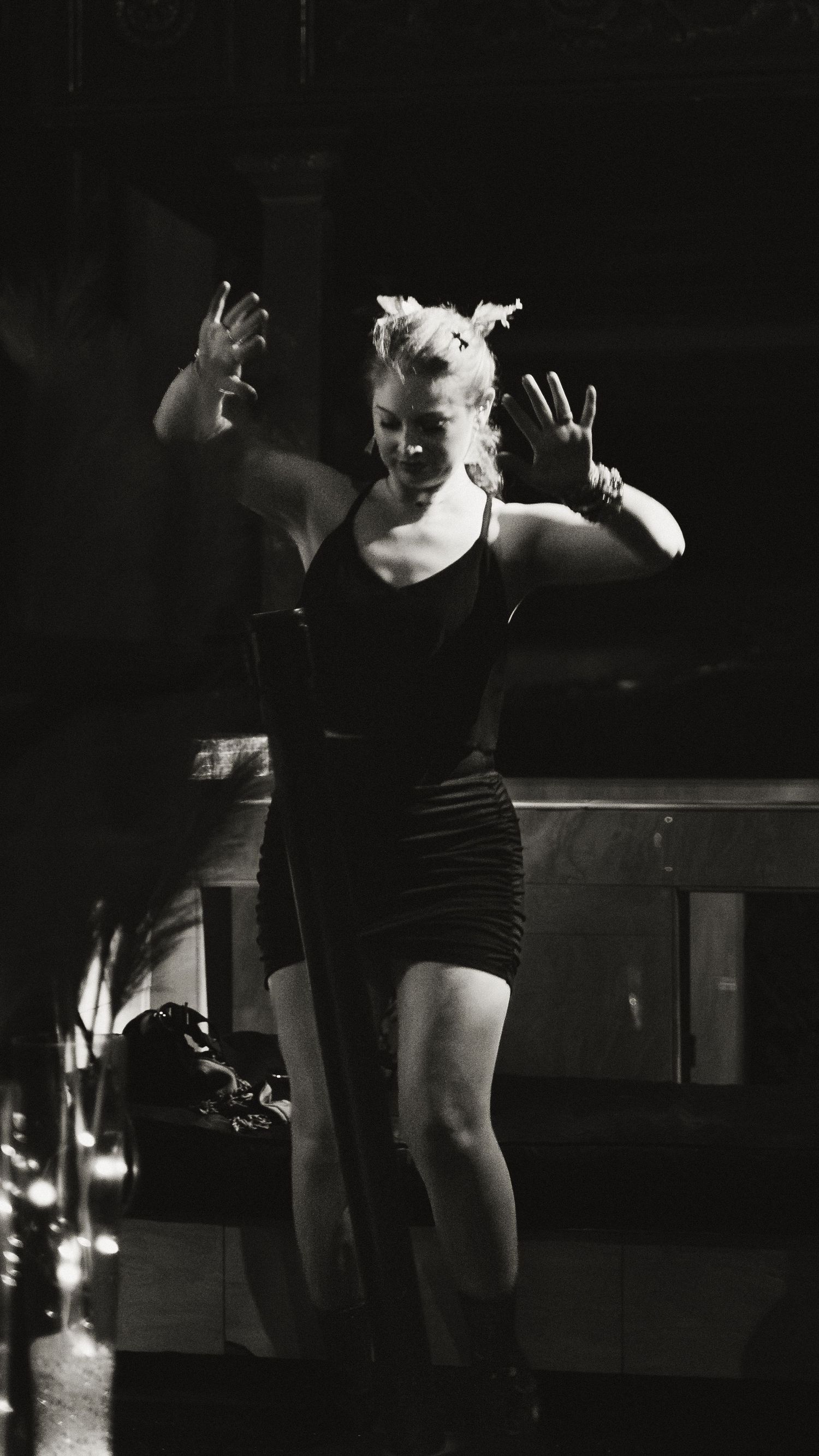 Dance performance captured in low-light conditions showing fluid movements and gestures.