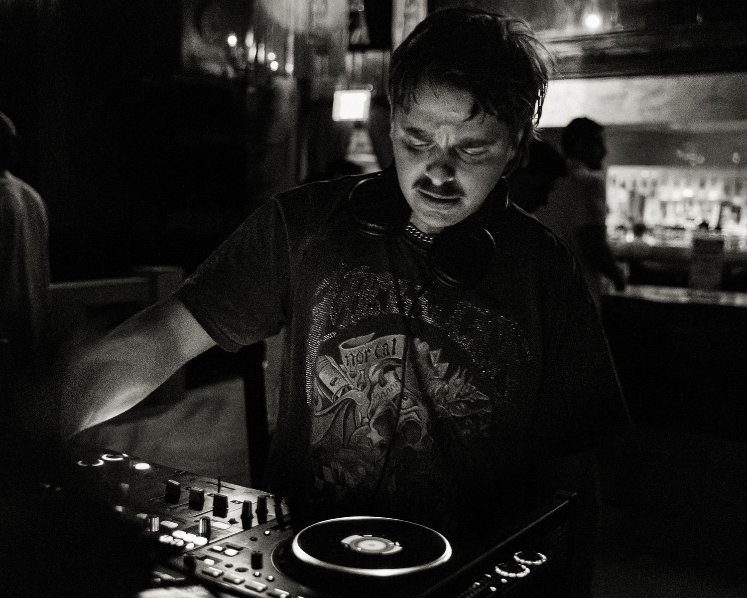 Close-up of turntables and DJ equipment in dramatic low-key lighting.
