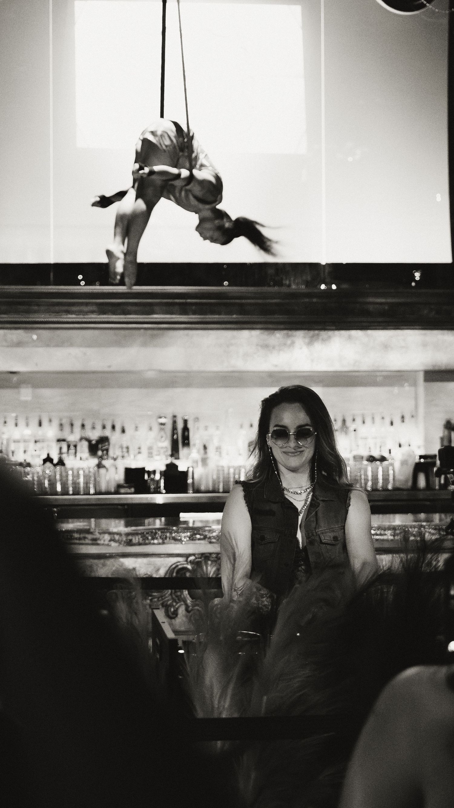Artistic black and white shots of a bar scene with dramatic lighting and reflective surfaces.