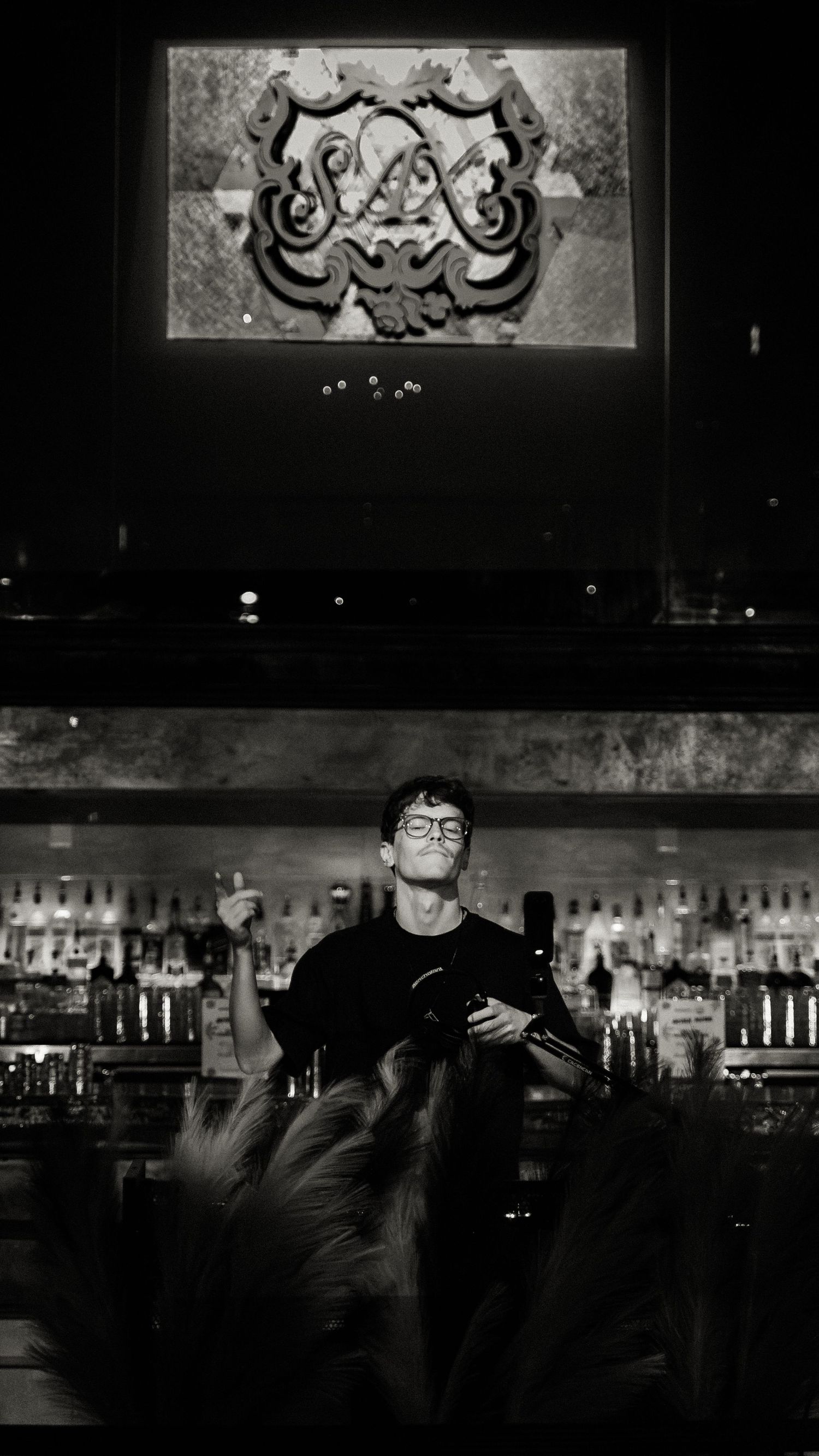 Atmospheric black and white photos of a bar interior with decorative lighting fixtures.