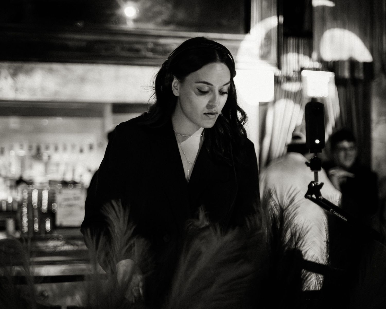 Atmospheric black and white photo of a dimly lit bar interior.