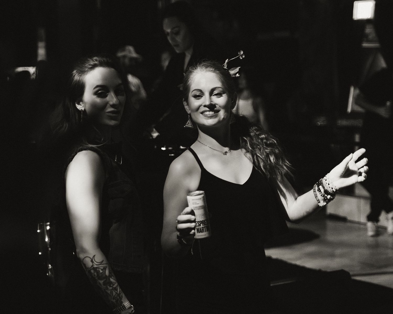 Moody black and white sequence showing social interaction in a dark setting.