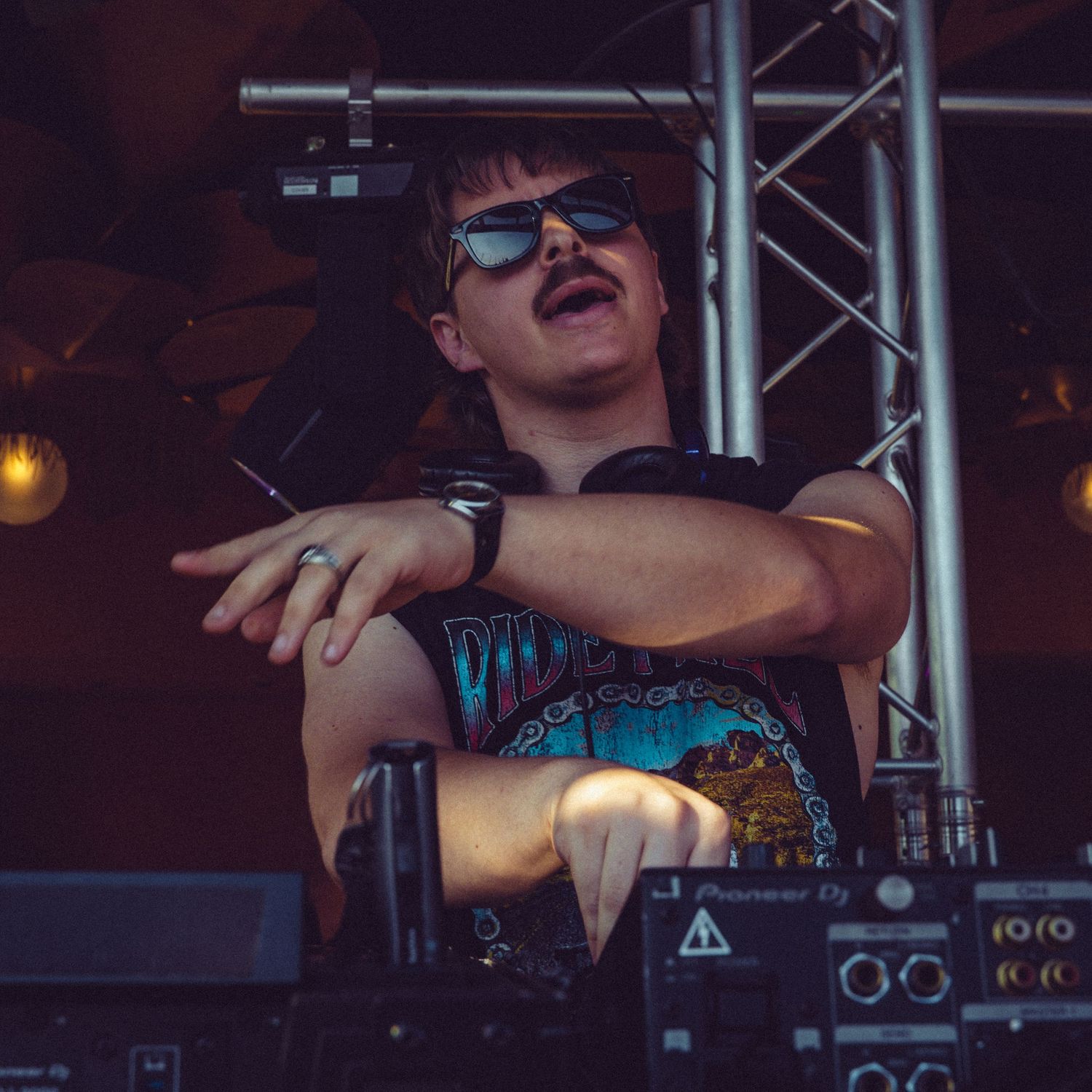 DJ working the controls on professional audio equipment during a live performance.