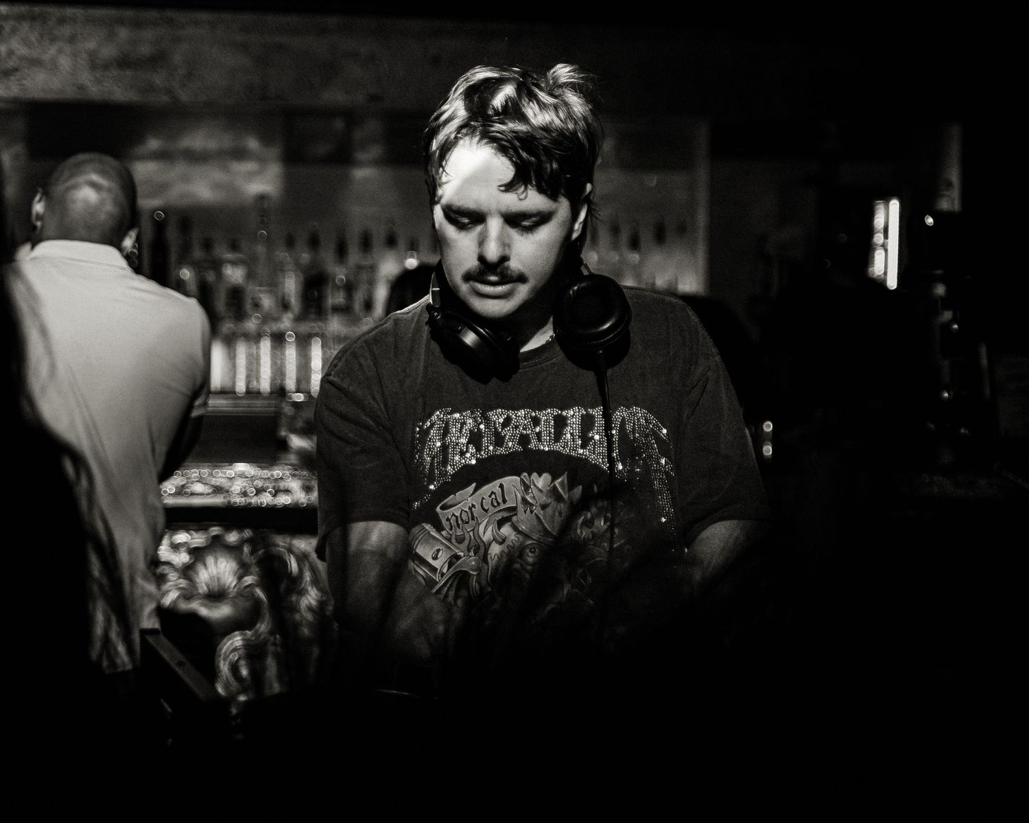 Dark moody shot of a DJ setup in a nightclub environment.