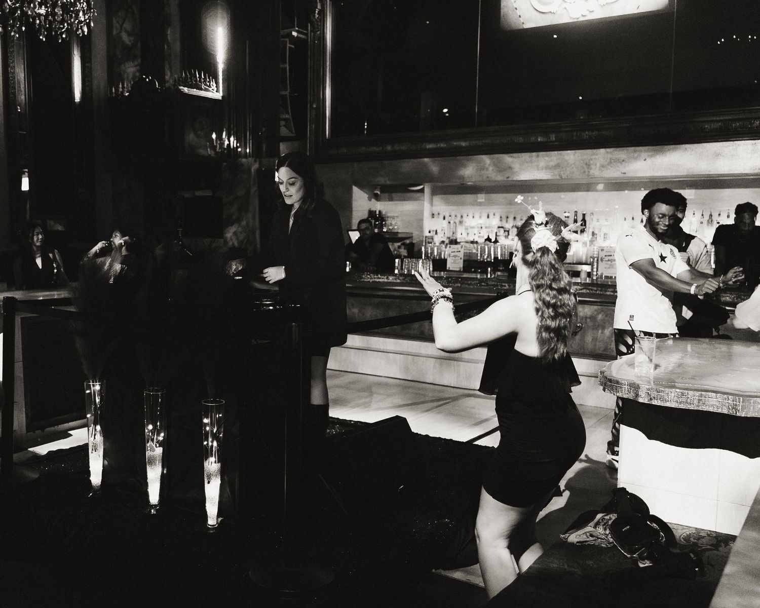 Dramatic monochrome performance sequence captured in a dimly lit venue with silhouetted figures.