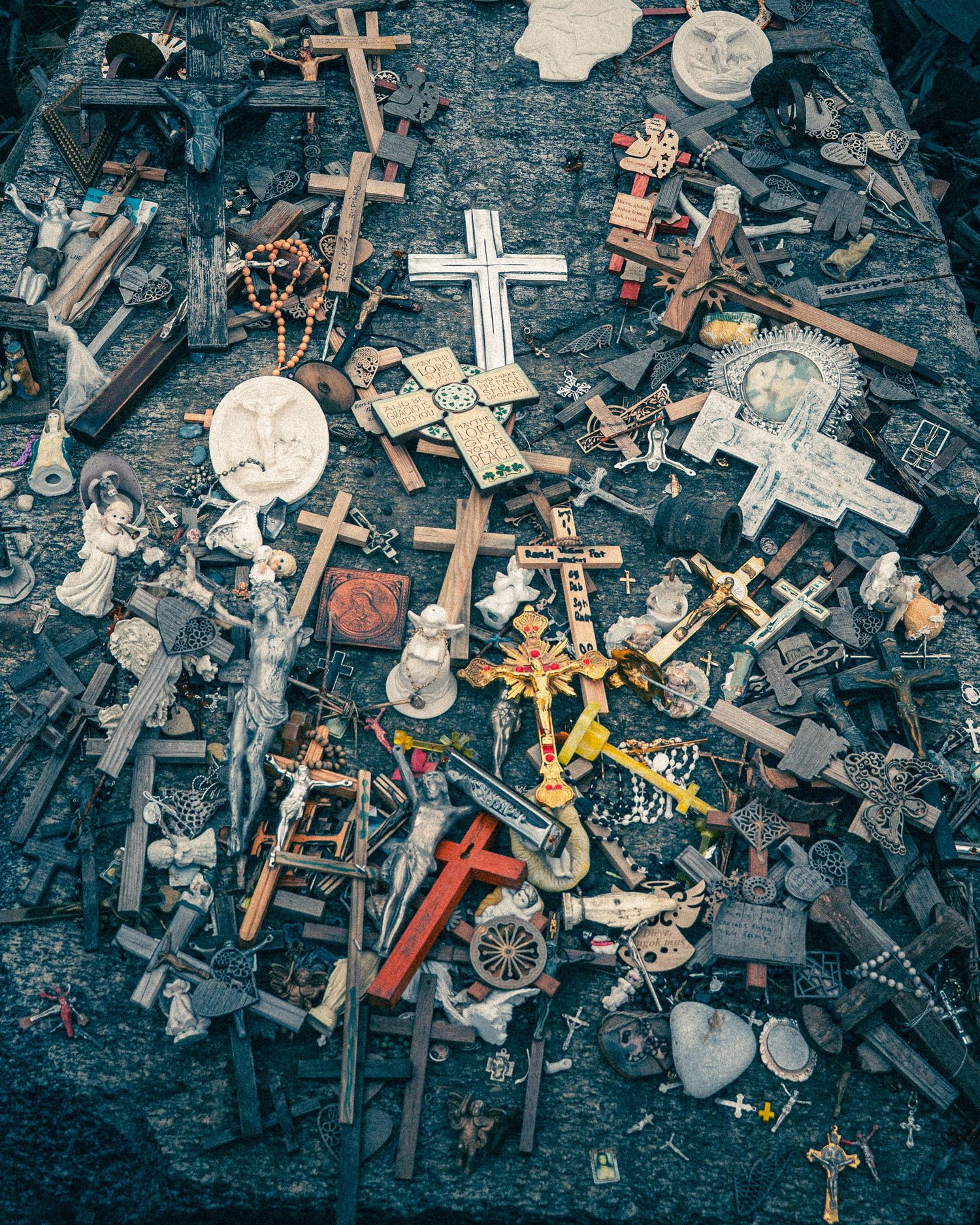 Collection of diverse religious crosses and artifacts scattered on dark ground.