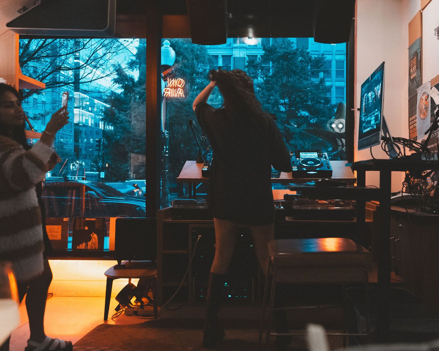 Dark atmospheric lounge space with silhouettes and blue window light.