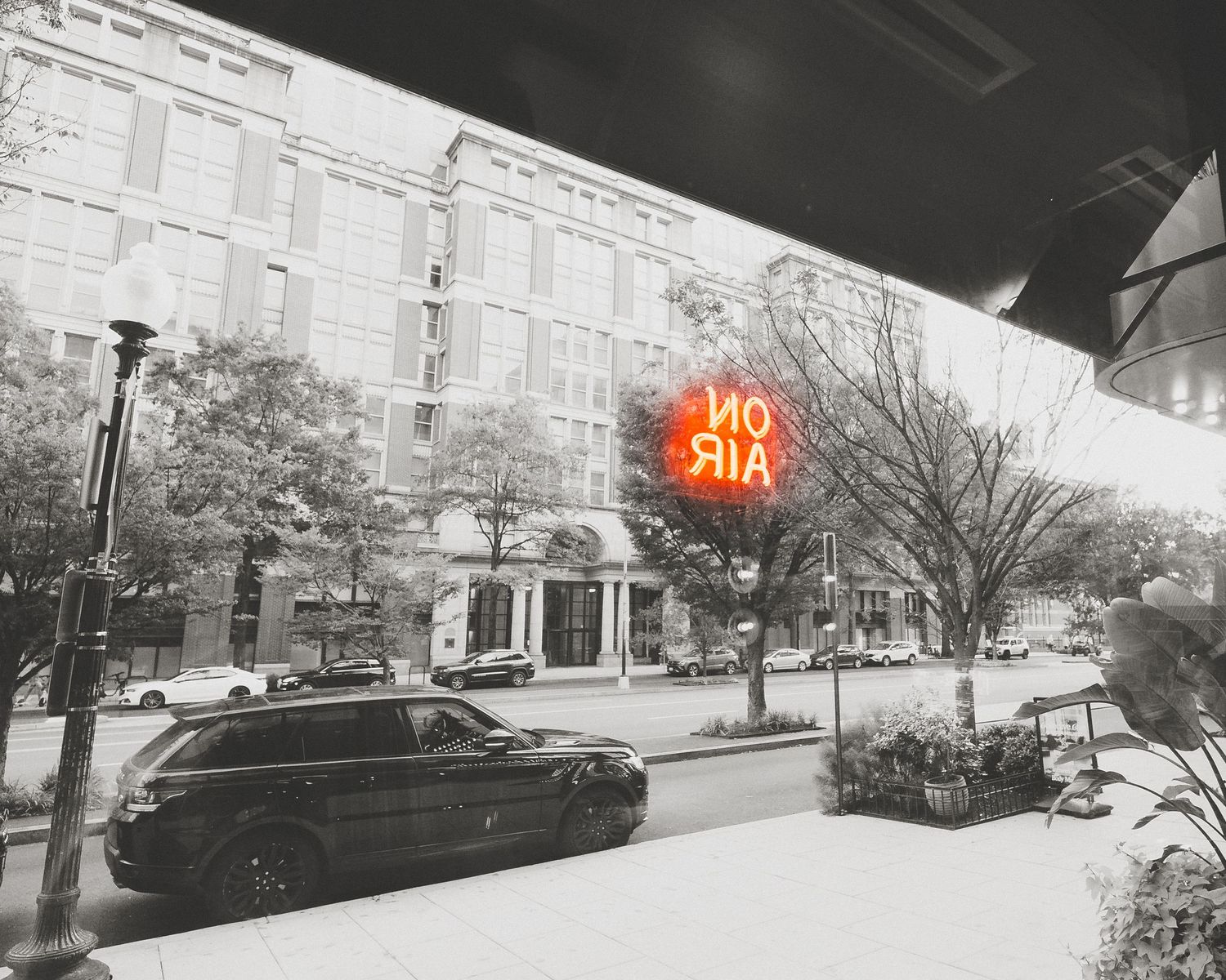 Black and white panoramic street view showing parked cars and buildings with a vintage aesthetic.