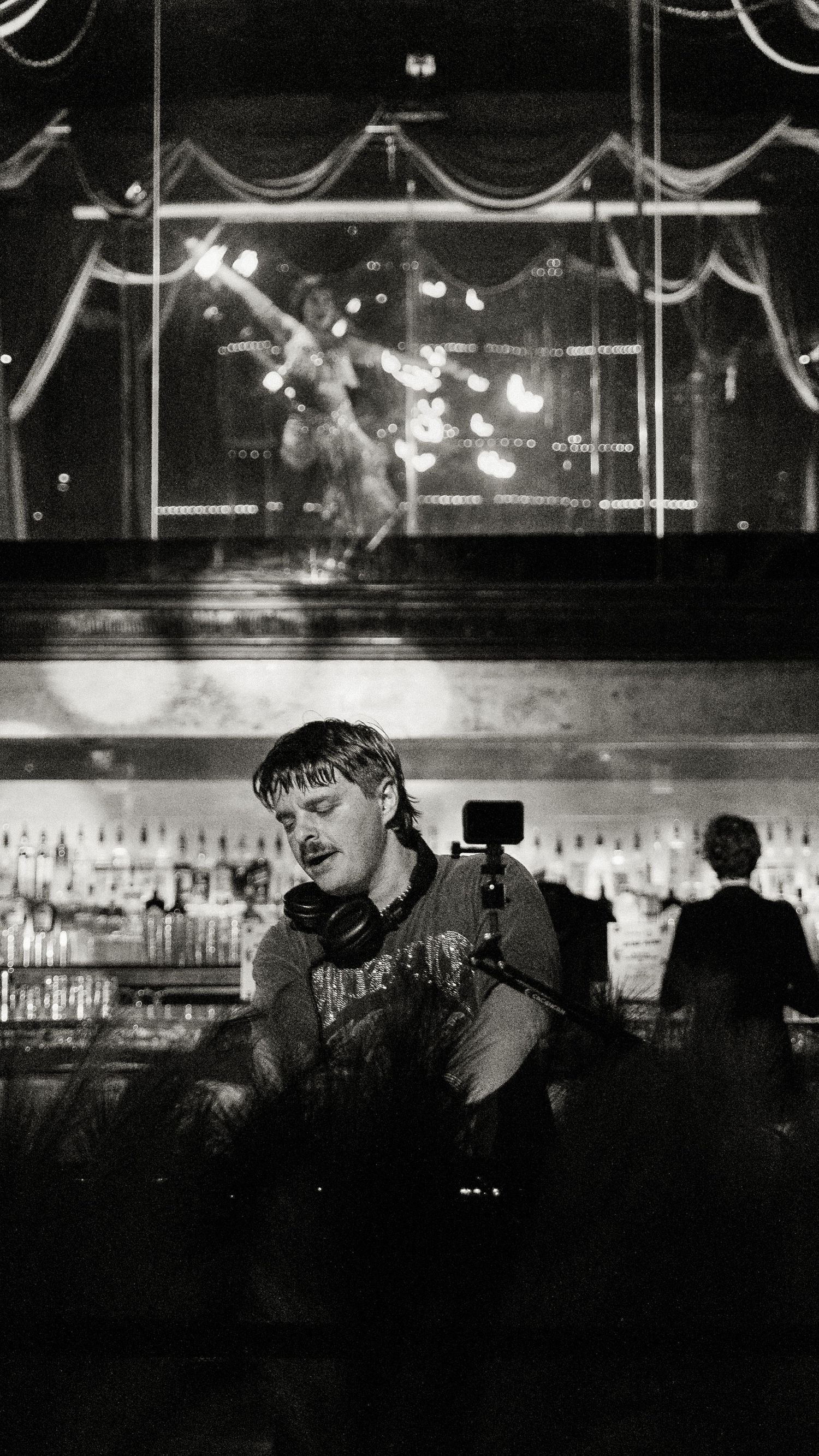 Bar counter with decorative lighting and bottles displayed in black and white.