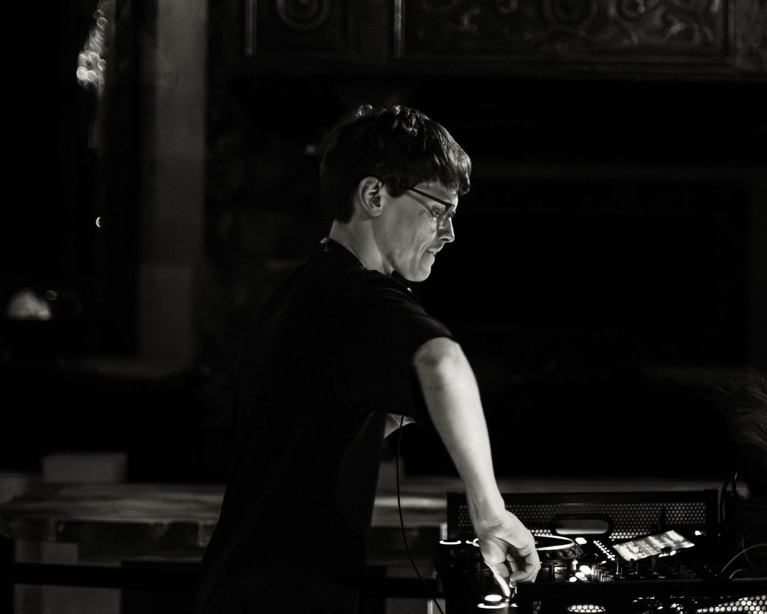 Dark silhouetted figure performing against dramatic lighting in a club setting.