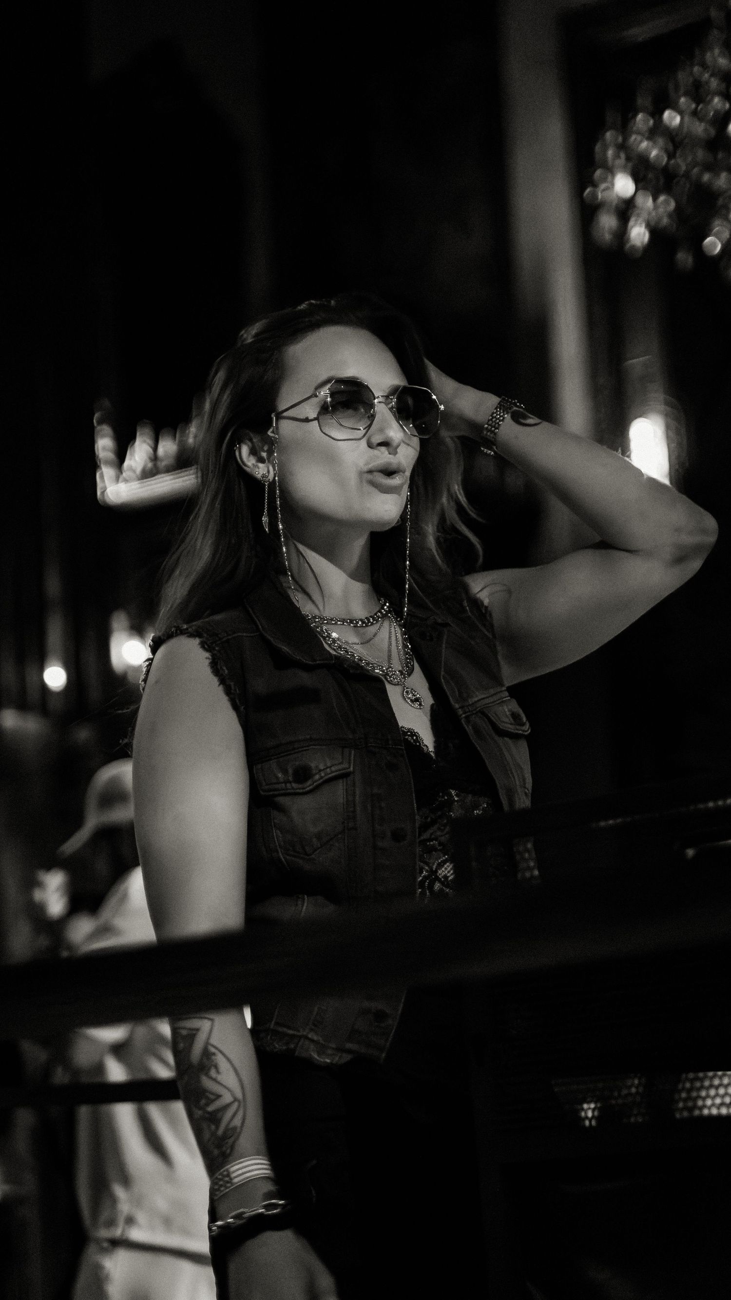 Performer in denim vest and glasses captured in dramatic black and white shots.