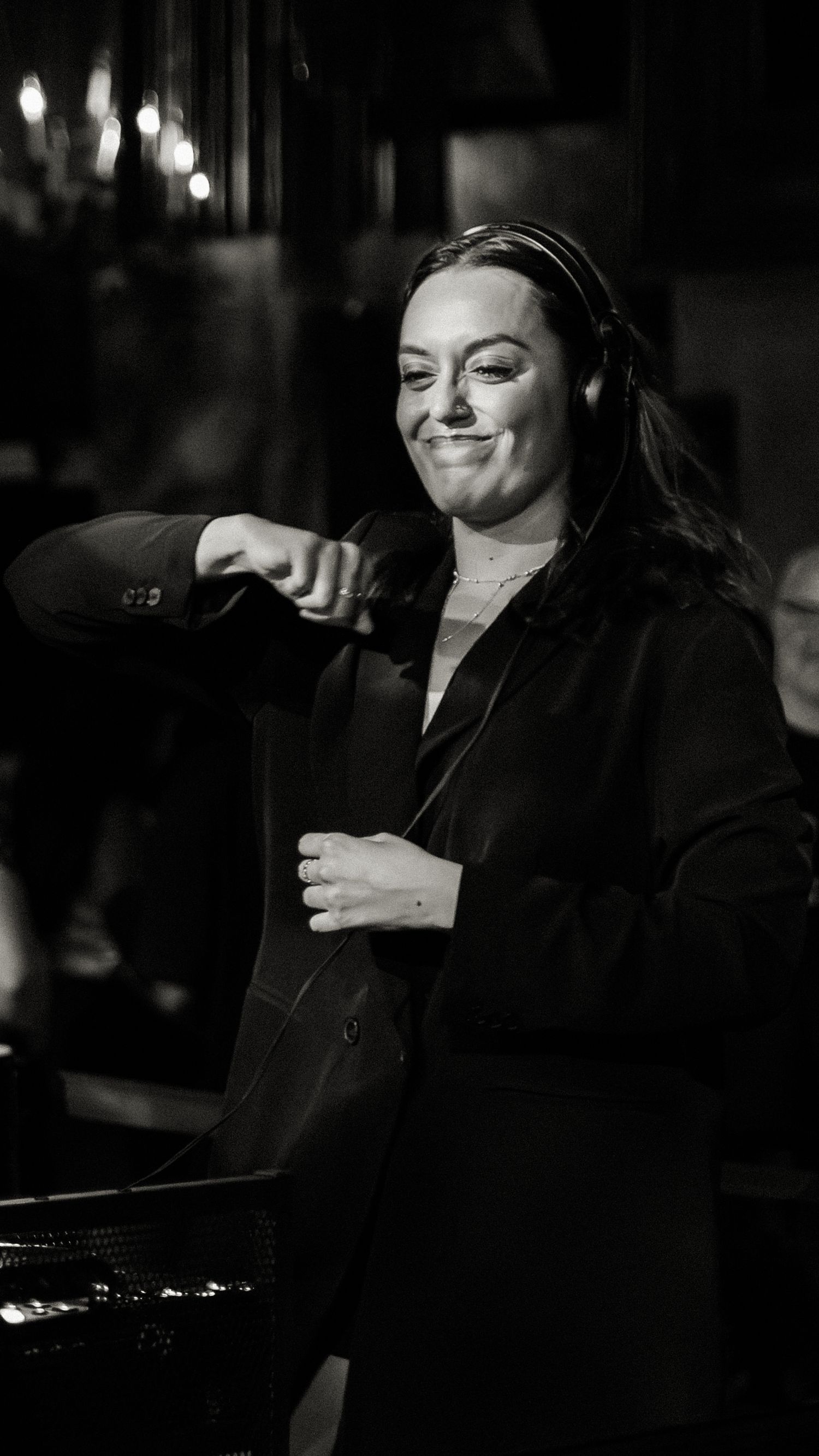 A series of black and white photos showing someone laughing and gesturing expressively in low light.