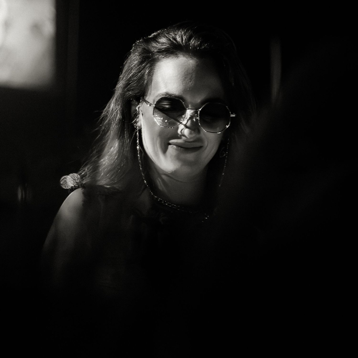 Atmospheric black and white nightclub scene with dramatic lighting and silhouettes.