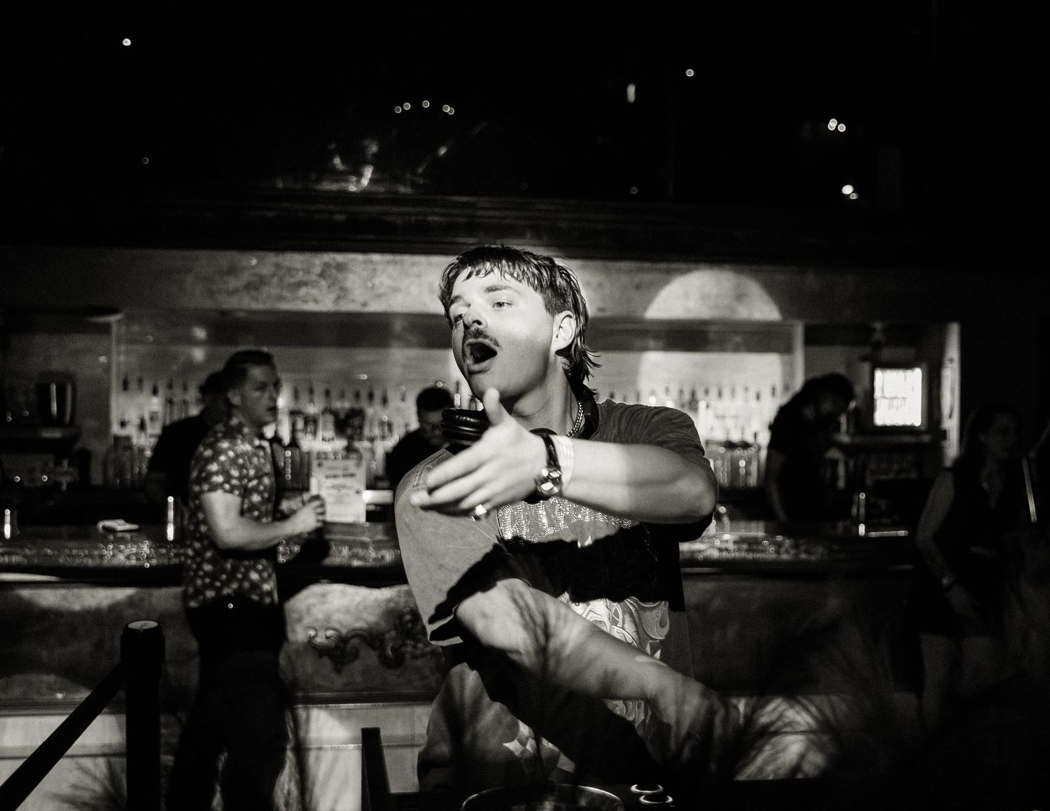 Energetic crowd scene at a dimly lit nightclub bar.