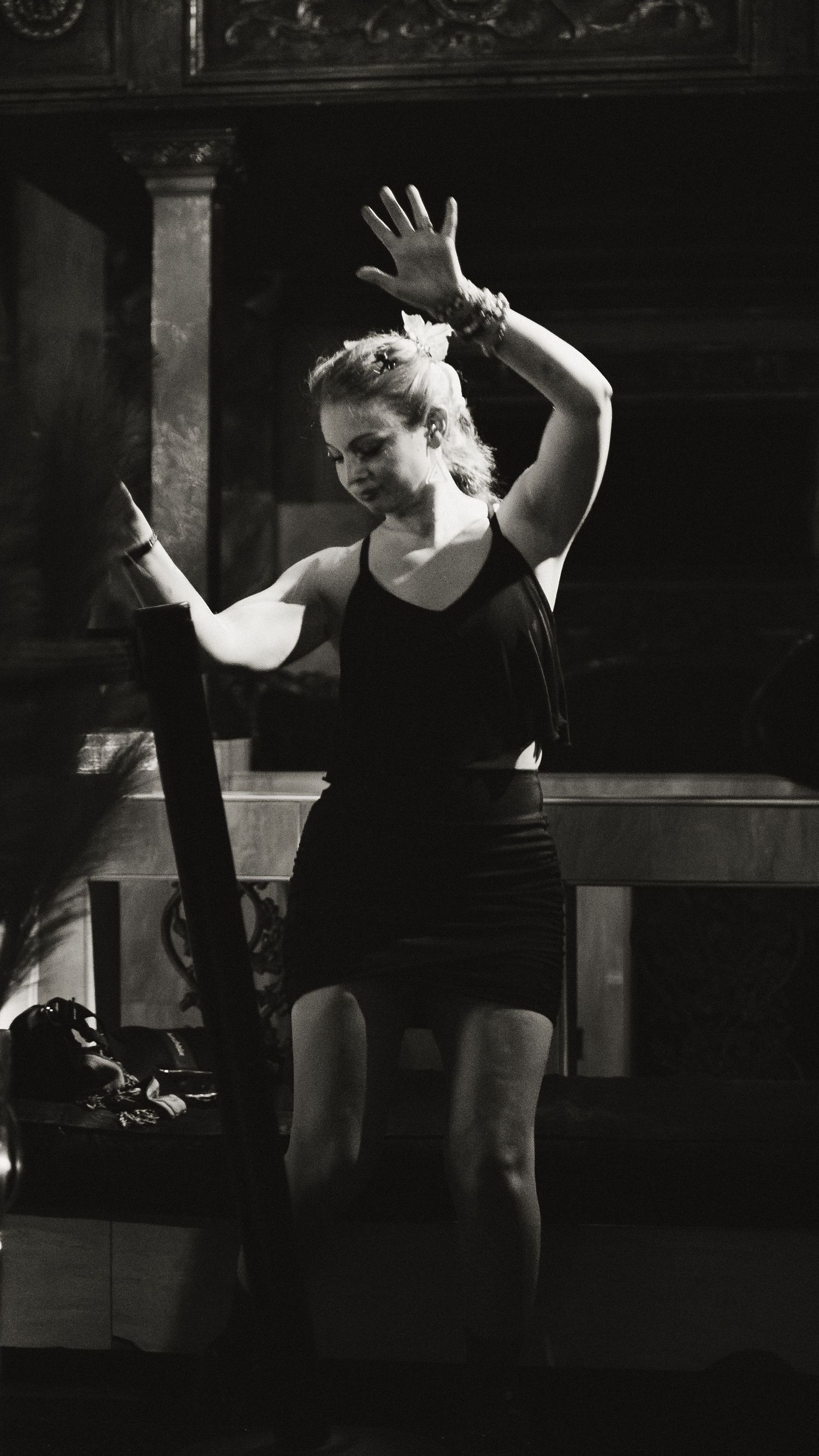 Black and white sequence showing dancers in motion performing choreographed movements in a dark space.