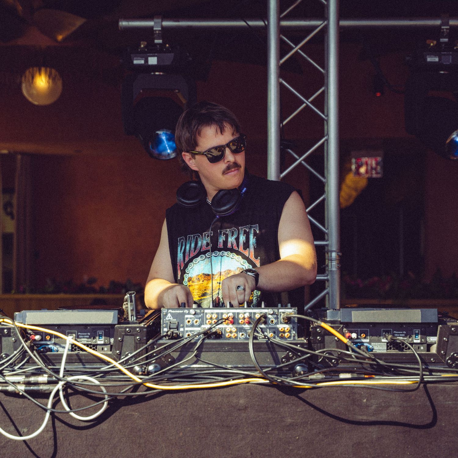 DJ concentrating while performing with professional mixing equipment at indoor venue.
