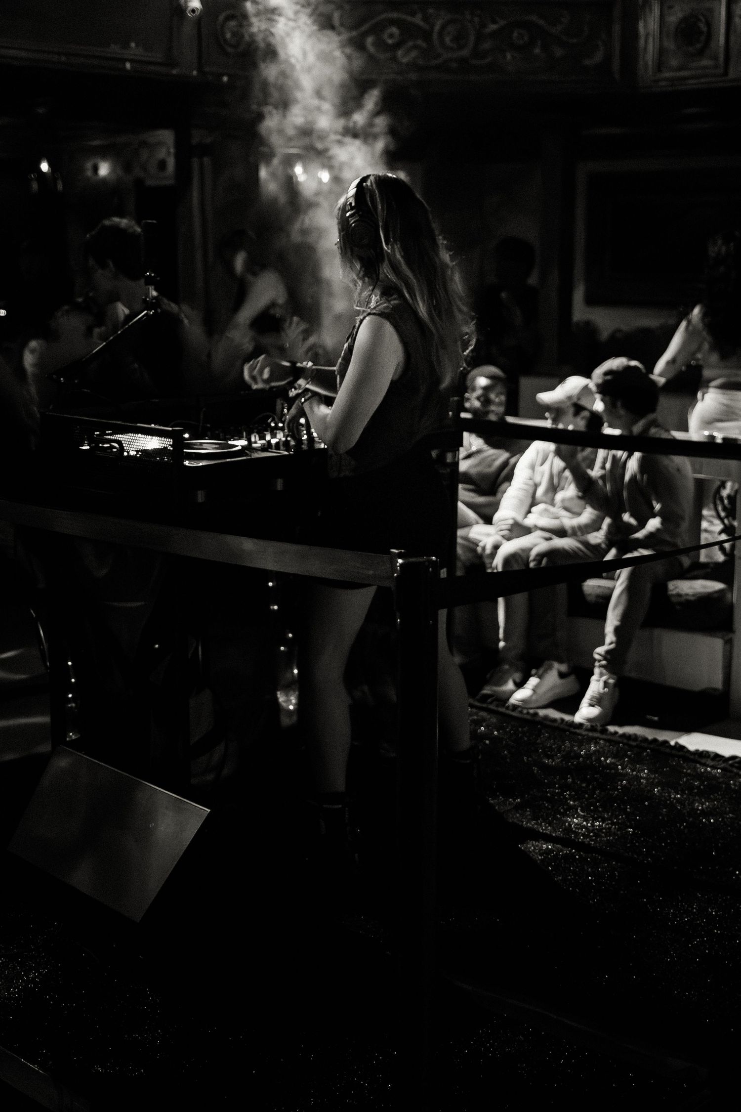 Atmospheric black and white nightclub scene with dramatic lighting and smoke effects.