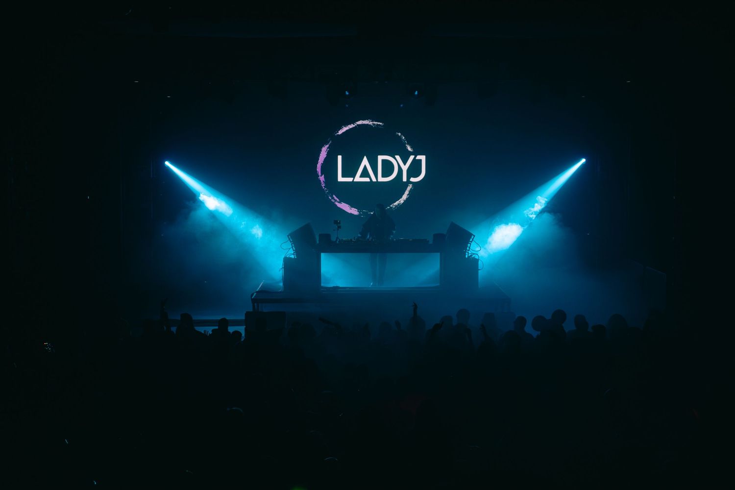 Glowing blue neon lights illuminate a dark stage or venue creating a dramatic atmospheric effect.