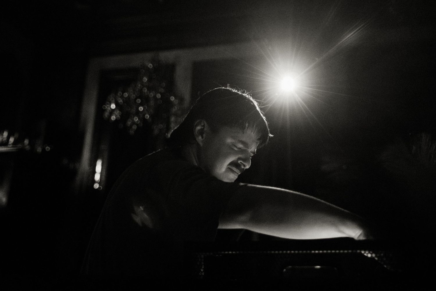 Bright spotlight creating dramatic beams in a dark nightclub setting.