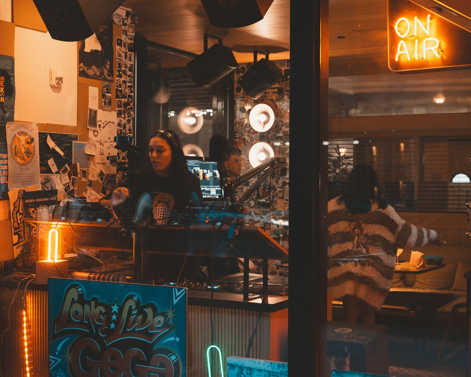 Interior of a bar or lounge with orange neon signs and blue accent lighting.