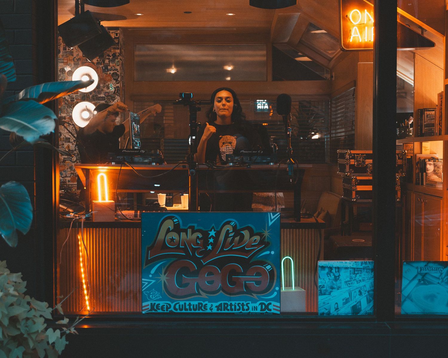 Nightclub or bar space with blue and orange mood lighting and decorative signage.