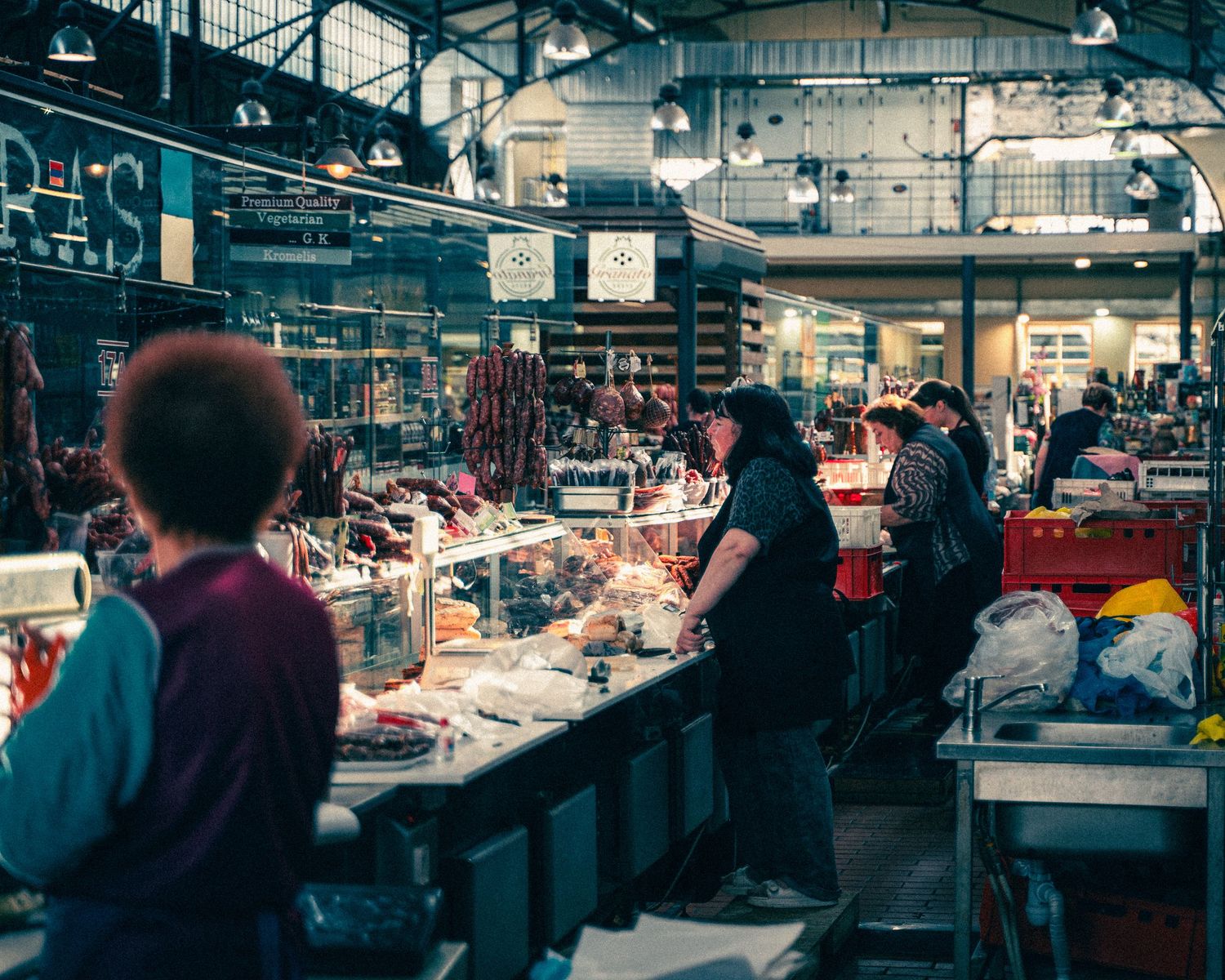 Indoor market hall with meat counters and vendors stretching into the distance.