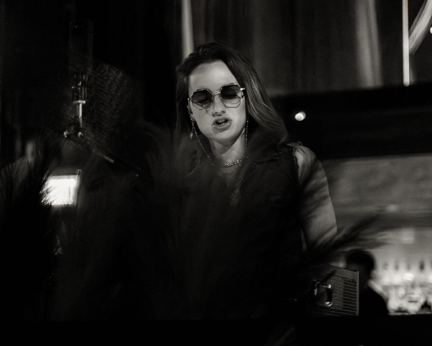 Series of noir-style photographs showing a nightclub performance in low light.