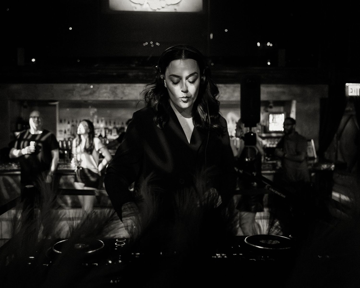 Dramatic black and white nightclub scene with low lighting and silhouettes.