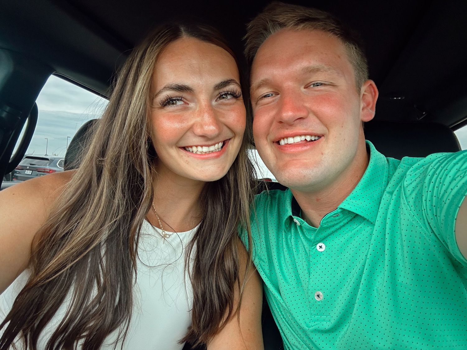 A couple takes a series of selfies together in a car, wearing casual attire including a green shirt and white top.