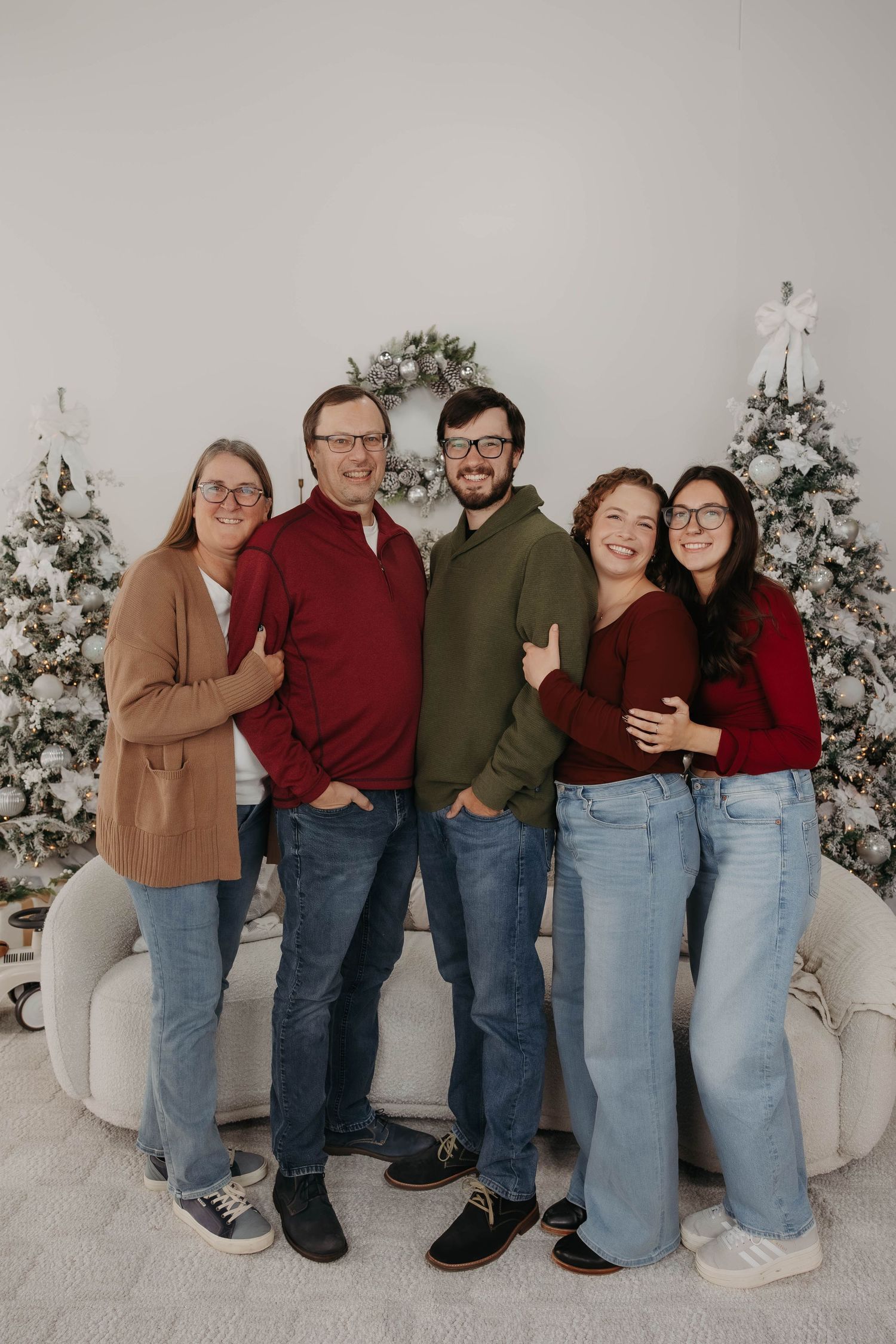 Group photo of family members wearing coordinated casual outfits against white backdrop.