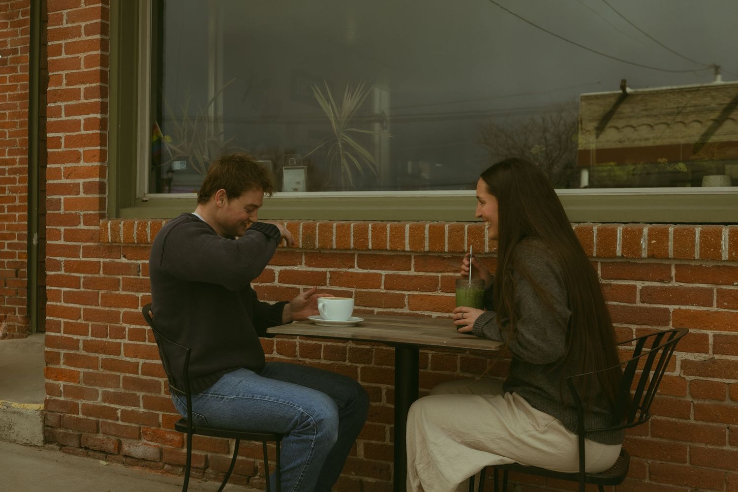 People sit at a long counter in a diner with exposed brick walls and vintage decor.