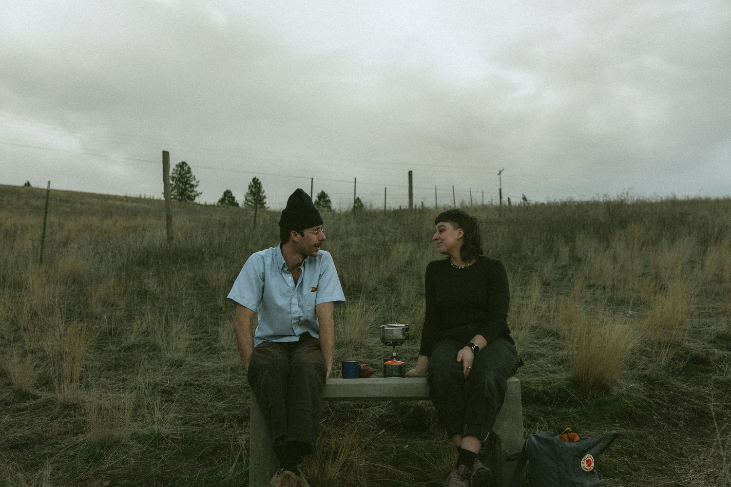 Panoramic view of a barren rural landscape with figures standing in the distance.