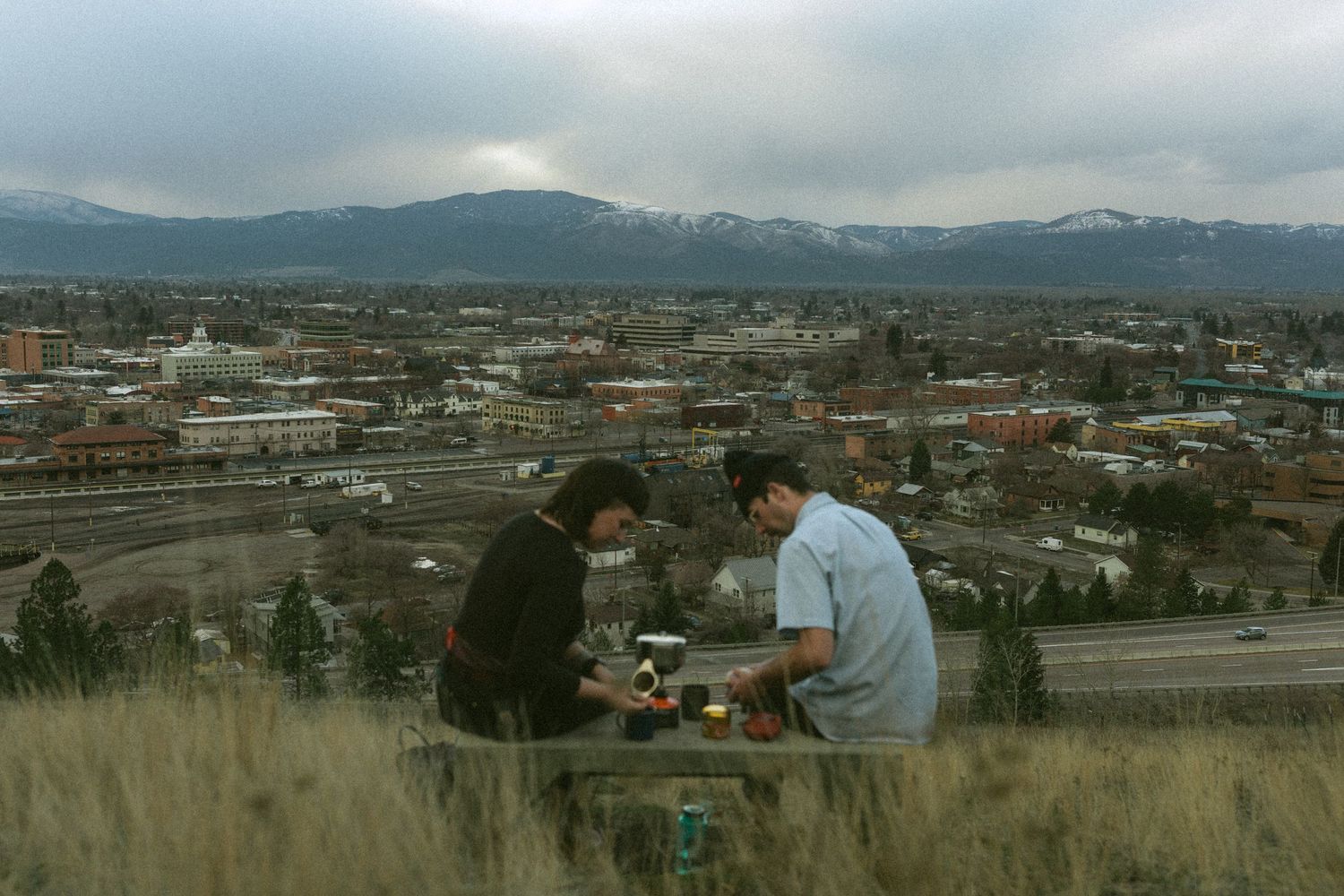 A panoramic view of a suburban landscape with mountains in the distance and buildings scattered across the valley.
