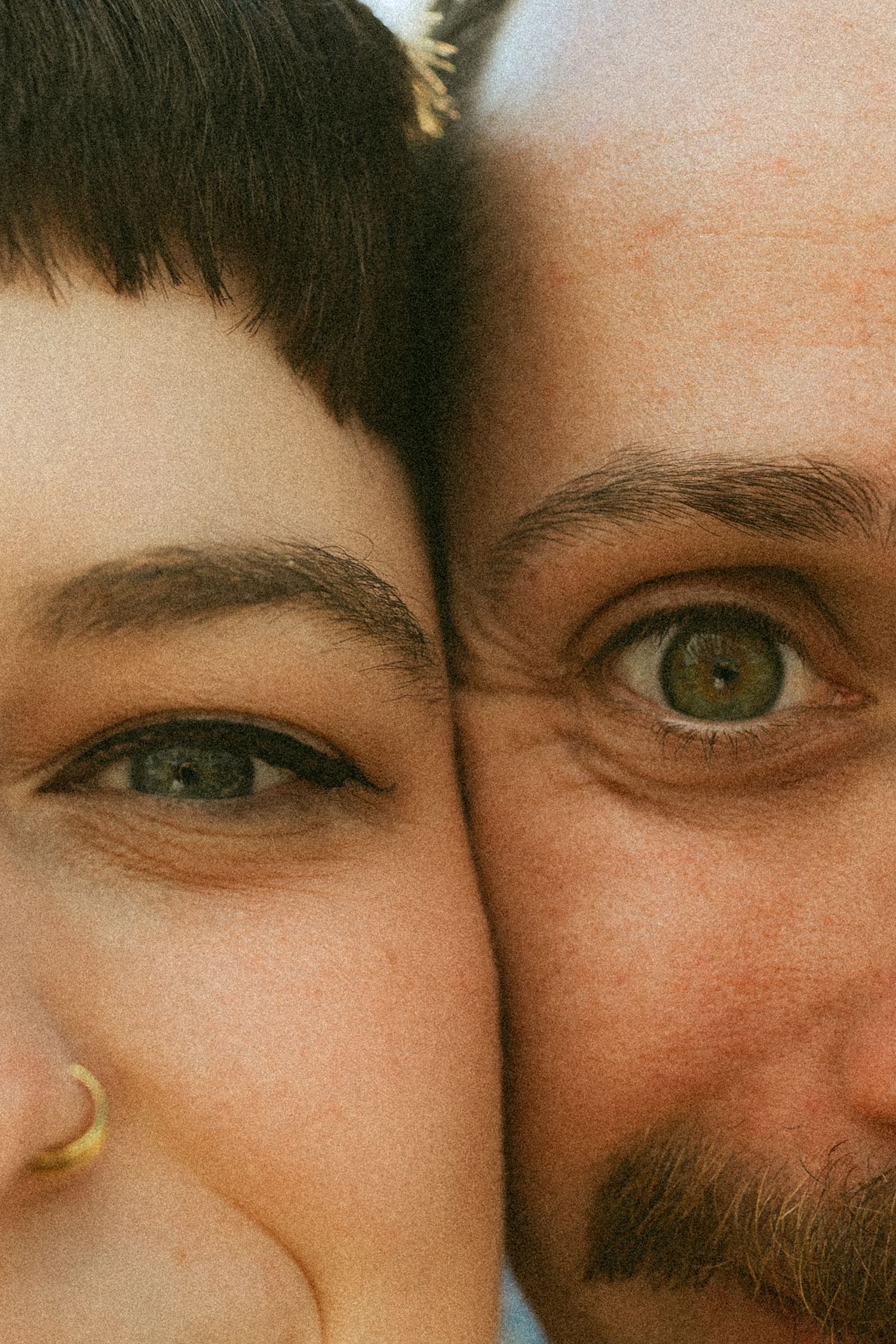 Close up artistic portrait showing eyes and partial faces in warm lighting.