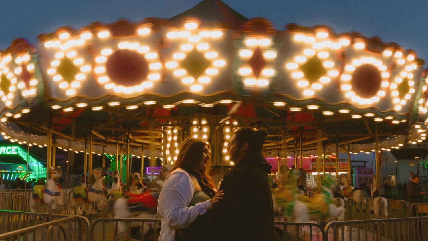Illuminated carousel with glowing lights at night creates a romantic and magical carnival atmosphere.