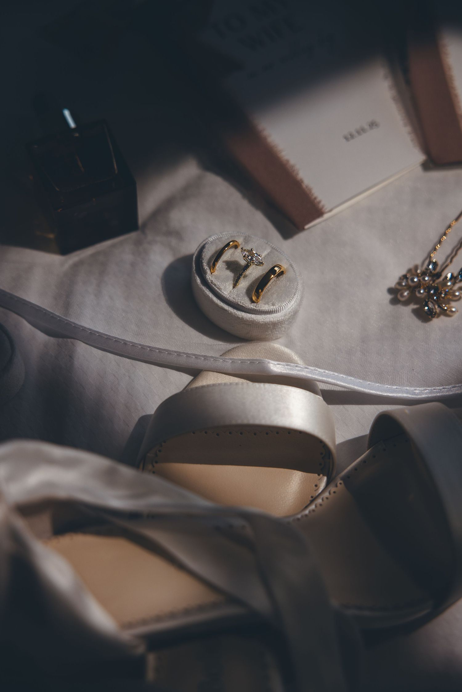 Wedding shoes and accessories photographed in moody lighting with soft focus.